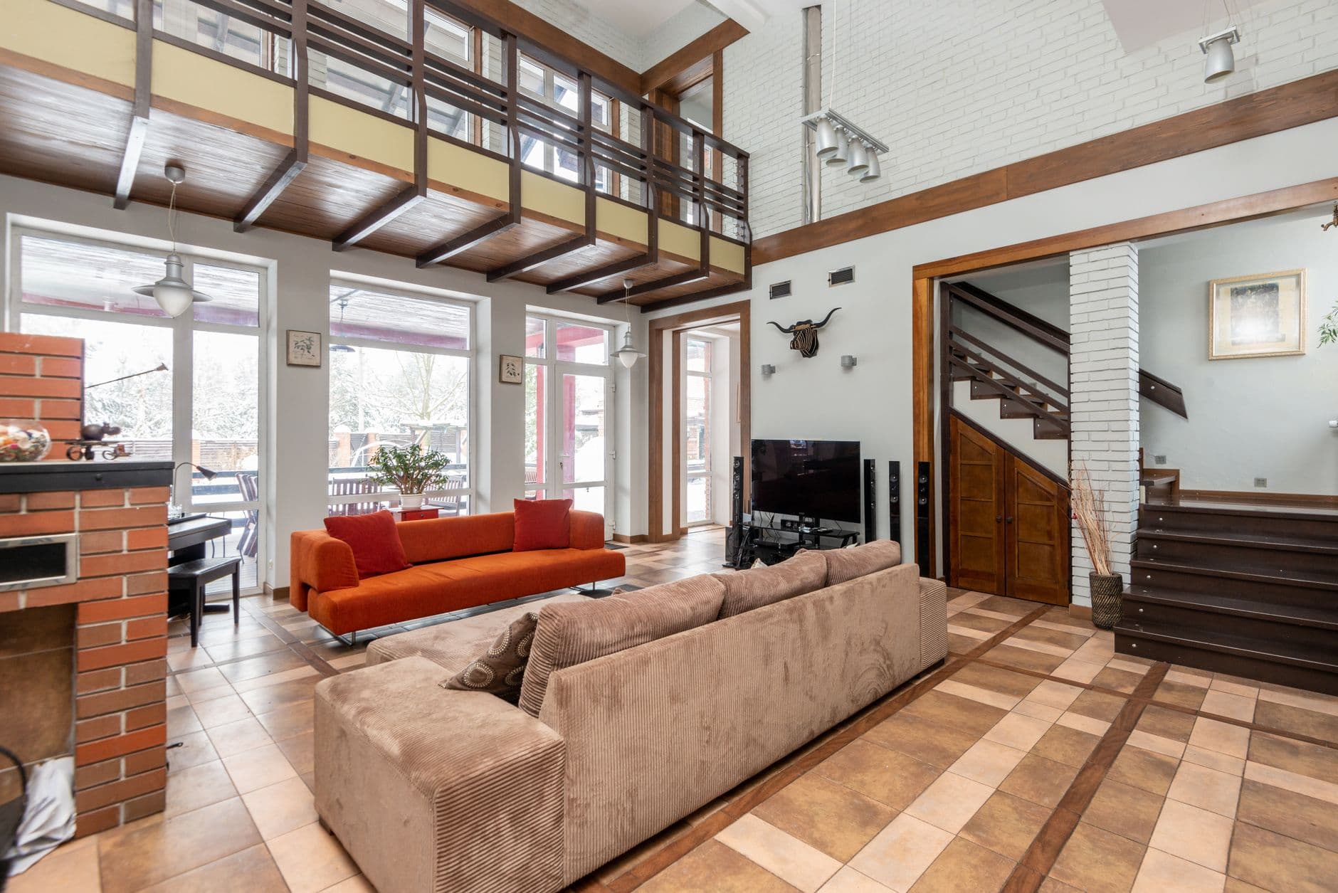 Monte-escalier moderne installe sur escalier droit dans maison contemporaine avec fauteuil beige